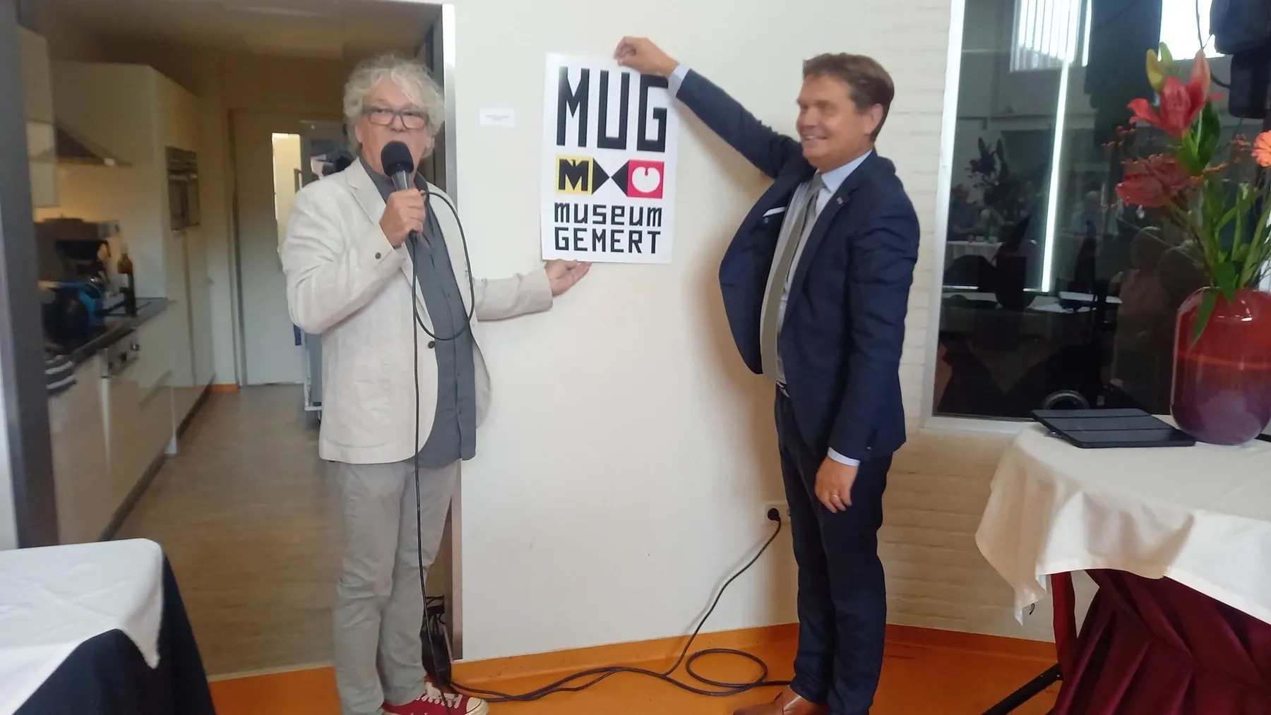 Voorzitter Ton Hendriks en burgemeester Michiel van Veen onthullen het MUG-logo